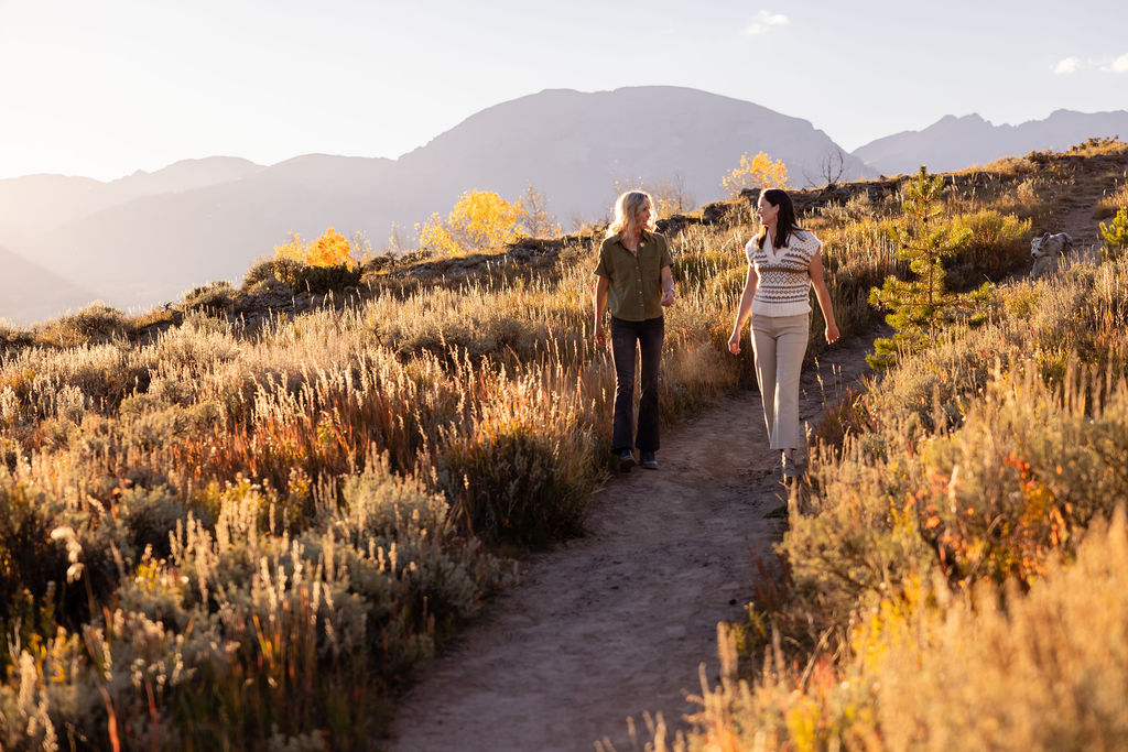 Dr. Holly Hickman and Dr. Julie McKenzie walking together on a Summit County trail at golden hour, with mountains rising in the distance